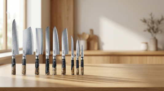 Japanese Damascus knives with black coloured resin handles arranged on a light oak kitchen worktop
